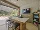 Beautiful outdoor kitchen complete with bar seating, a grill, sink, television, and view of the pool at 554 Estates Pl, Longwood, FL 32779