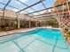 Spacious screened-in pool area with an outdoor kitchen, dining area, lounge seating, and a basketball hoop for enjoyment at 554 Estates Pl, Longwood, FL 32779