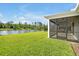 Lush green backyard lawn with a screened patio overlooking a tranquil pond at 10002 Brown Burrow St, Orlando, FL 32829