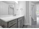 Bathroom features a gray vanity with quartz countertop and large mirror at 10002 Brown Burrow St, Orlando, FL 32829
