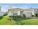 Charming home boasts a manicured lawn, stone facade accents, and a brick paver driveway leading to the garage at 10002 Brown Burrow St, Orlando, FL 32829