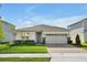 Beautiful single-story home featuring a well-maintained lawn, stone accents, and a two-car garage at 10002 Brown Burrow St, Orlando, FL 32829