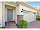 Charming home exterior features a blue front door, brick accents, and a two-car garage at 10002 Brown Burrow St, Orlando, FL 32829