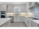 Bright kitchen features white cabinets, stainless steel appliances, and a tiled backsplash at 10002 Brown Burrow St, Orlando, FL 32829