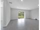 Open living area with large tile flooring, neutral walls, and sliding glass doors overlooking a pond at 10002 Brown Burrow St, Orlando, FL 32829