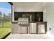 Outdoor kitchen with stainless steel grill, granite countertop, and refrigerator at 10002 Brown Burrow St, Orlando, FL 32829
