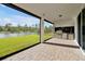 Open patio with brick floors and outdoor kitchen area overlooks lake and backyard at 10002 Brown Burrow St, Orlando, FL 32829