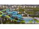 Aerial view of community waterpark with multiple slides, open green spaces, and playground at 1013 Leader St, Davenport, FL 33896