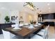 Open-concept dining and living area with a wooden dining table, white chairs, and a view of the kitchen at 1013 Leader St, Davenport, FL 33896