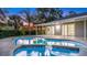 Backyard view with in-ground pool, spa, and covered patio with sliding glass door into the living room at 1027 Dees Dr, Oviedo, FL 32765