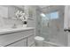 Renovated bathroom offers a glass shower, white cabinets, brushed nickel fixtures and a modern design at 1027 Dees Dr, Oviedo, FL 32765