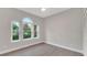 The bedroom offers hardwood floors, neutral paint, and a trio of windows overlooking the pool at 1027 Dees Dr, Oviedo, FL 32765