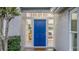 Inviting entryway with a striking blue door framed by decorative windows and trimmed hedges at 1027 Dees Dr, Oviedo, FL 32765