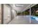 Covered patio with sliding glass doors to backyard oasis with pool, trees, and sunset at 1027 Dees Dr, Oviedo, FL 32765