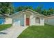 Charming single-story home with a well-manicured lawn, red door, and attached garage at 1073 Hamlet Dr, Maitland, FL 32751
