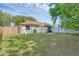 Spacious backyard with lawn, wood fence, mature trees, and a screened-in patio at 1397 Candlewyck Dr, Orlando, FL 32807