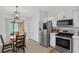 Bright kitchen with stainless steel appliances, white cabinetry, and adjacent dining area at 1397 Candlewyck Dr, Orlando, FL 32807