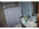 A basic bathroom featuring a bathtub with a shower curtain, a toilet, and a small vanity sink at 14057 Ithaca Way, Orlando, FL 32826