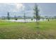 Expansive backyard overlooking a serene lake, with a green lawn and walking path at 1412 Brentwood Dr, Kissimmee, FL 34746