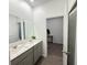 Bright bathroom with double vanity, quartz countertops, and wood-look tile flooring at 1412 Brentwood Dr, Kissimmee, FL 34746