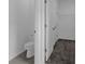 A bathroom and walk-in closet featuring a toilet, shelving and neutral carpet at 1412 Brentwood Dr, Kissimmee, FL 34746