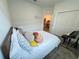 Cozy bedroom featuring a bed with plush pillows, a closet, and view into a brightly lit adjoining room at 1412 Brentwood Dr, Kissimmee, FL 34746