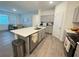 Stylish kitchen with gray cabinets, a kitchen island with barstool seating, and stainless-steel appliances at 1412 Brentwood Dr, Kissimmee, FL 34746