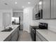 Well-appointed kitchen with island, stainless steel appliances, sleek black stovetop, and gray cabinetry at 1412 Brentwood Dr, Kissimmee, FL 34746