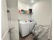 Functional laundry room with a washer, dryer, utility shelving, and neutral flooring at 1412 Brentwood Dr, Kissimmee, FL 34746