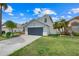 Beautiful single-Gathering home with mature landscaping, blue exterior, and a two-car garage at 1517 Abberton Dr, Orlando, FL 32837