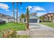 Beautiful two-story home boasts mature landscaping including palm trees and a well-manicured lawn at 1517 Abberton Dr, Orlando, FL 32837