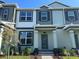 Inviting two-story townhouse featuring a covered entrance and lush landscaping at 15310 Burgtheater Dr, Winter Garden, FL 34787