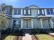 Inviting townhouse featuring a covered entrance, brick walkway, and lush landscaping at 15310 Burgtheater Dr, Winter Garden, FL 34787