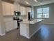 Well-lit kitchen showcasing white cabinets, an island, and stainless steel appliances at 15310 Burgtheater Dr, Winter Garden, FL 34787