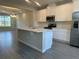 Modern kitchen with stainless steel appliances, a center island, and wood-look tile flooring at 15310 Burgtheater Dr, Winter Garden, FL 34787