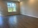 Bright, spacious living room with wood-look tile and large windows offering neighborhood views at 15310 Burgtheater Dr, Winter Garden, FL 34787