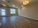 Spacious living area featuring wood-look tile flooring, a chandelier, and plenty of natural light at 15310 Burgtheater Dr, Winter Garden, FL 34787