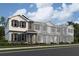 New two-story townhome with a modern facade, gray accents, and manicured landscaping under a cloudy sky at 15363 Burgtheater Dr, Winter Garden, FL 34787