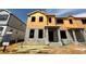 Two-story townhome under construction with visible framing and building materials on a sunny day at 15363 Burgtheater Dr, Winter Garden, FL 34787