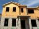 Construction view of the two-story townhome showing the framing and cinder block on a sunny day at 15363 Burgtheater Dr, Winter Garden, FL 34787