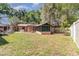 Backyard showing home, screened porch, and a partial view of an outbuilding at 1860 Ne 62Nd St, Ocala, FL 34479