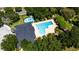 Aerial view of a community pool area with a pool and splash pad surrounded by trees at 2340 Grasmere View S Pkwy, Kissimmee, FL 34746