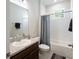 Well-lit bathroom features a shower and tub combination with a shower curtain and a large mirror above the sink at 2340 Grasmere View S Pkwy, Kissimmee, FL 34746