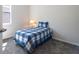 This well-lit bedroom features carpeted floors, a window with blinds, and a blue plaid comforter at 2340 Grasmere View S Pkwy, Kissimmee, FL 34746