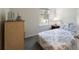 Comfortable bedroom features a patterned comforter on the bed, a window with blinds, and a dresser for storage at 2340 Grasmere View S Pkwy, Kissimmee, FL 34746