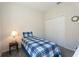 This well-lit bedroom features carpeted floors, a closet, and a blue plaid comforter and lamp at 2340 Grasmere View S Pkwy, Kissimmee, FL 34746