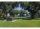 Scenic view of a community tennis court surrounded by lush greenery and trees at 2340 Grasmere View S Pkwy, Kissimmee, FL 34746