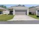 Charming single-story home features an attached two-car garage and a well-maintained lawn at 2340 Grasmere View S Pkwy, Kissimmee, FL 34746