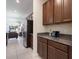Hallway view of kitchen and living room, with modern stainless steel refrigerator and granite counters at 2340 Grasmere View S Pkwy, Kissimmee, FL 34746