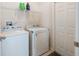 Functional laundry room with a washer, dryer, and overhead shelving for storage at 2340 Grasmere View S Pkwy, Kissimmee, FL 34746
